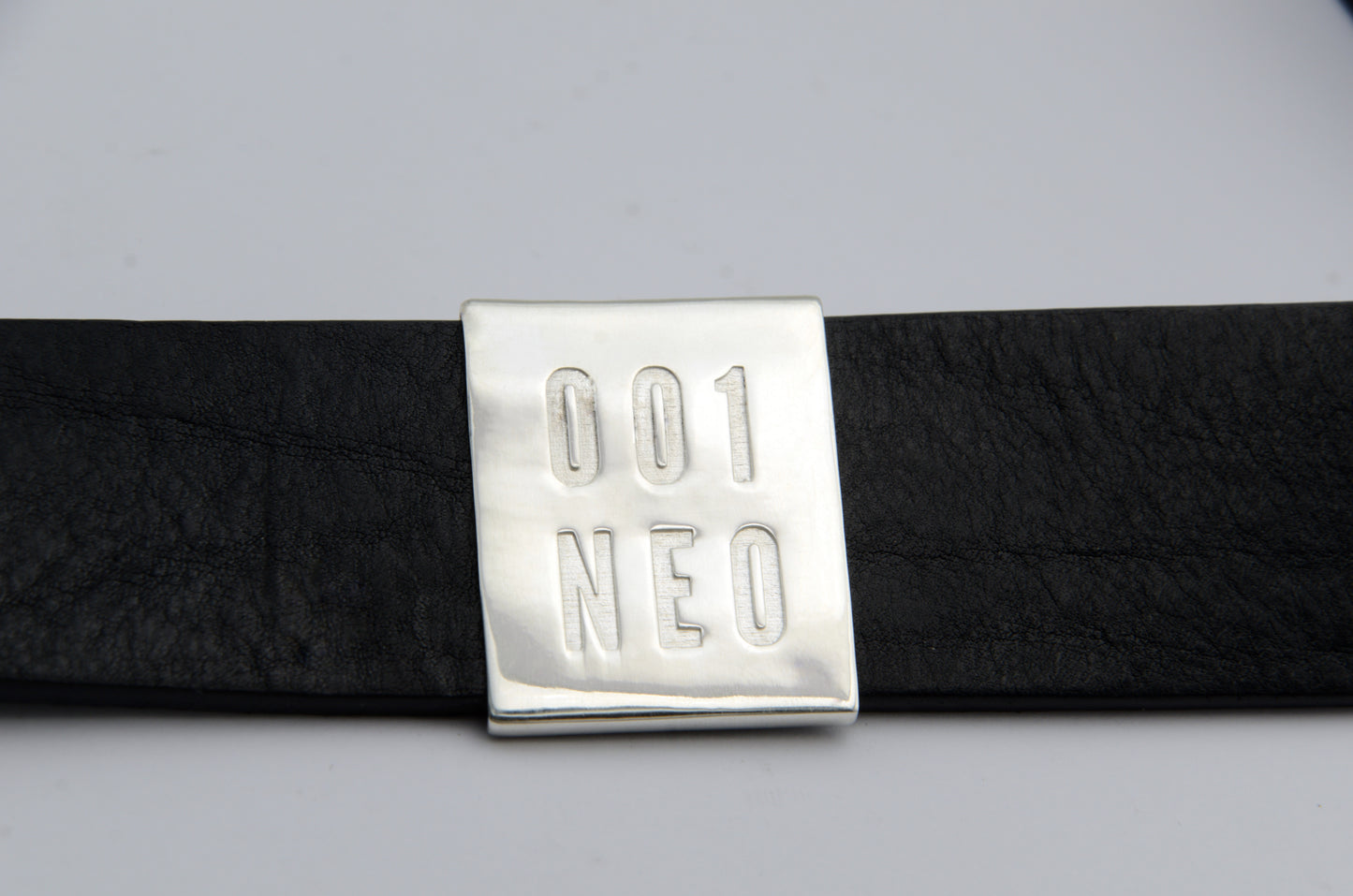 Black belt with a silver buckle labeled '001 NEO' on a light gray background